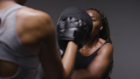 Studio-Shot-Of-Woman-Wearing-Boxing-Gloves-Sparring-With-Trainer-5